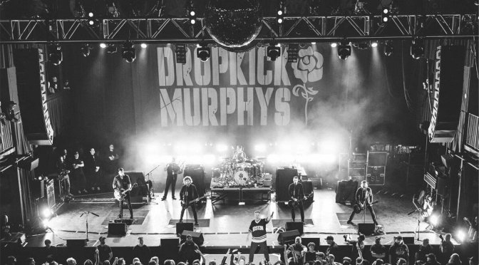 Dropkick Murphys performing live on stage in front of a packed crowd