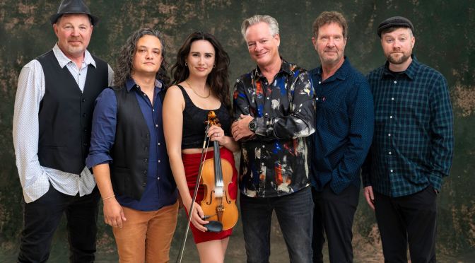 Kansas City Celtic rock band The Elders, six members posed against a dark green backdrop, fiddler holding her violin