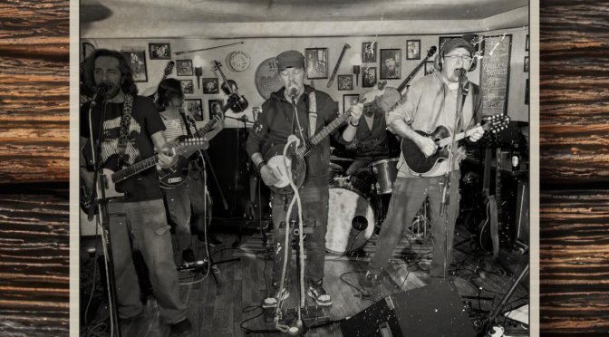 Whistling on Deck Sinking The Irish Rover EP cover: black-and-white photo of the five-piece band playing in a pub, framed on dark wood
